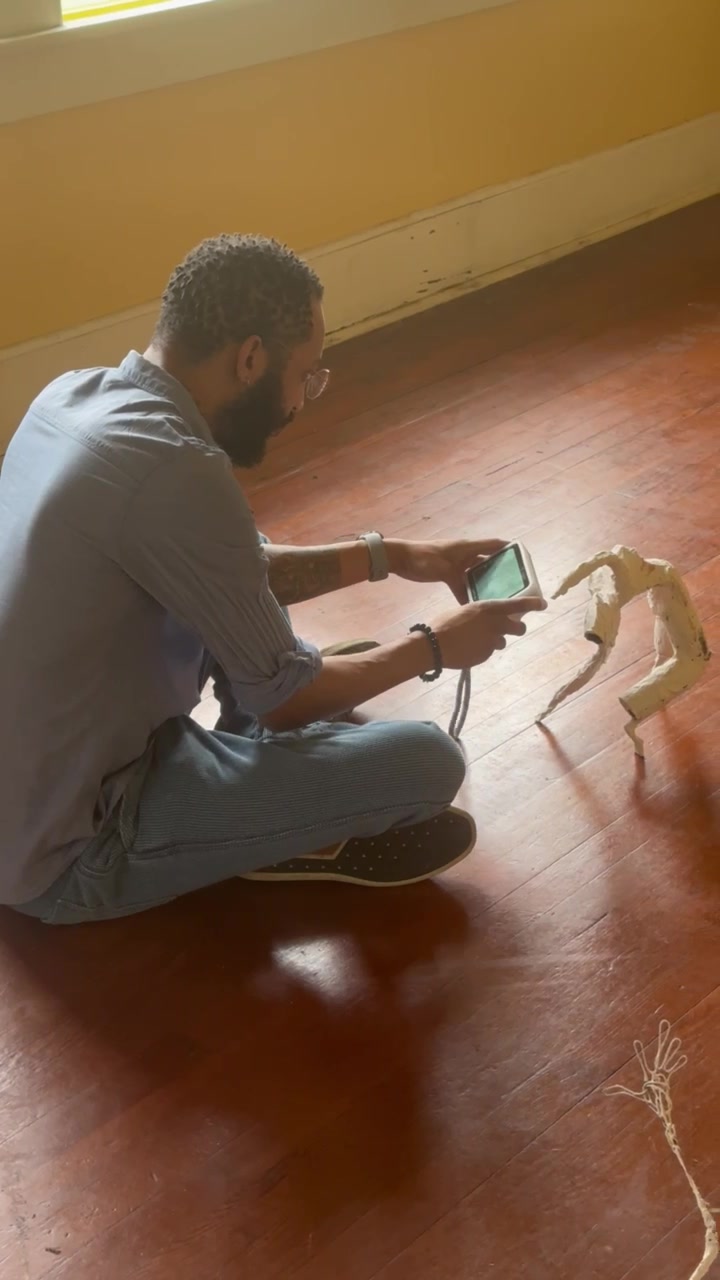 An adult uses a handheld 3D scanner to capture a small sculptural form at Rosser Gallery.